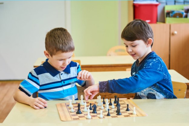 Ребенок играет в шахматы идея для фотосессии в саду